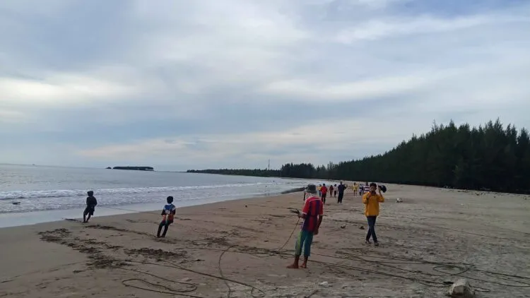 Tampak beberapa nelayan sedang menarik jala, dan pengunjung tengah mengambil foto di Pantai Tan Sridano, Senin (21/12/2020). (Genta Andalas/Fauzan Fajari)